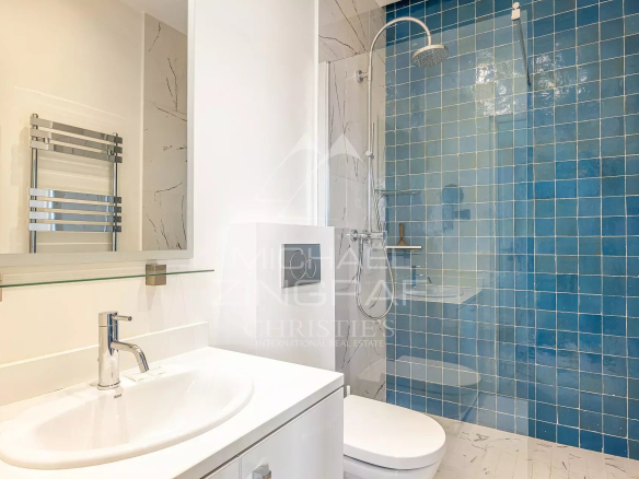 Salle de douche moderne avec carrelage bleu et lavabo dans un appartement à Cannes.
