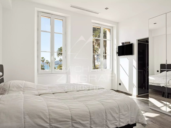 Room in a renovated penthouse in Cannes with windows overlooking the sea.