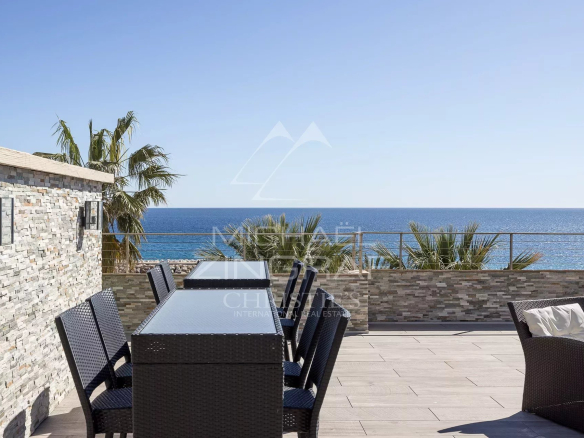 Rooftop terrace of a penthouse in Cannes with sea view and outdoor furniture.