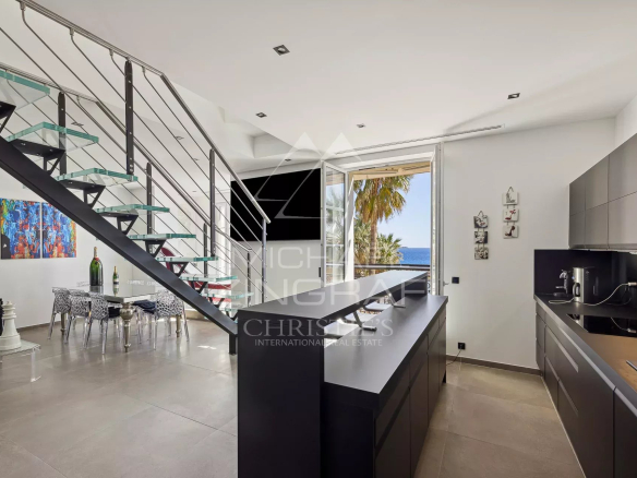 Intérieur d'un penthouse rénové avec cuisine moderne et vue sur la mer à Cannes.