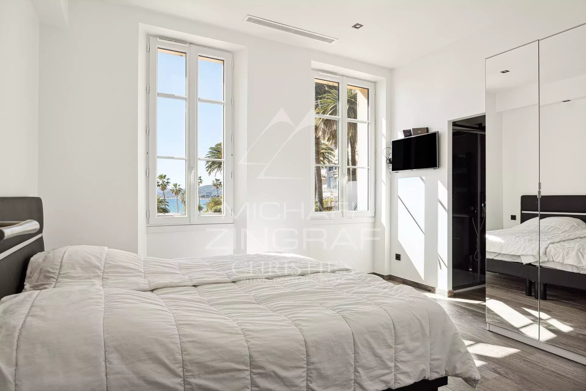 Chambre du penthouse à Cannes Chambre d'un penthouse rénové à Cannes avec fenêtres et vue sur la mer.