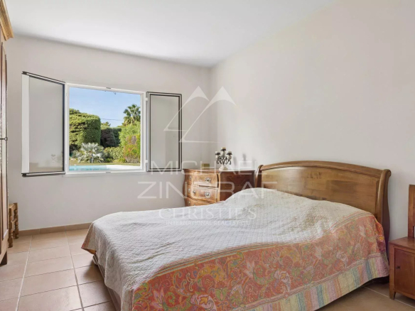 Chambre d'une villa à Antibes avec vue sur le jardin et la piscine.