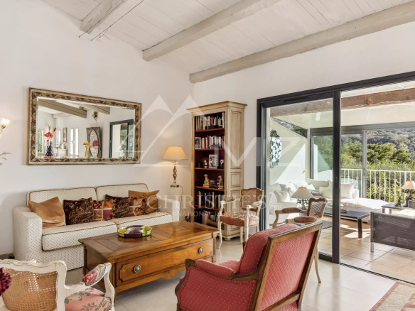 Intérieur d'une villa familiale à Cannes avec salon, cheminée et véranda.
