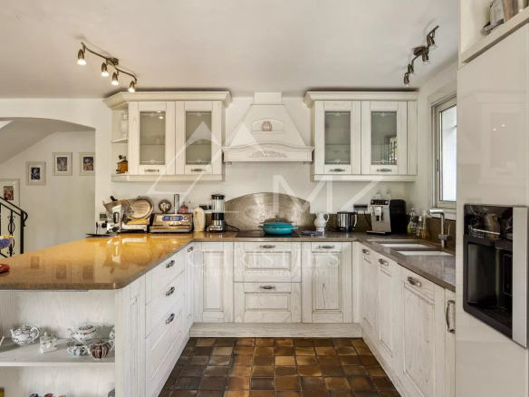 Cuisine moderne et équipée d'une villa familiale à Cannes, avec meubles en bois et comptoir en granit.