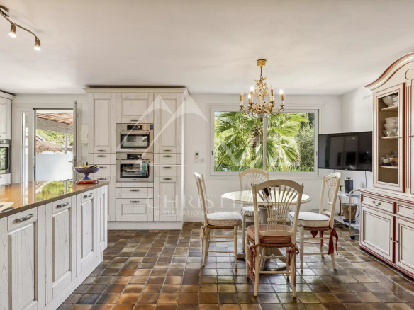 Cuisine d'une villa familiale à Cannes, avec meubles en bois et table à manger.