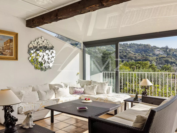 Intérieur d'une villa familiale à Cannes avec salon lumineux et véranda.
