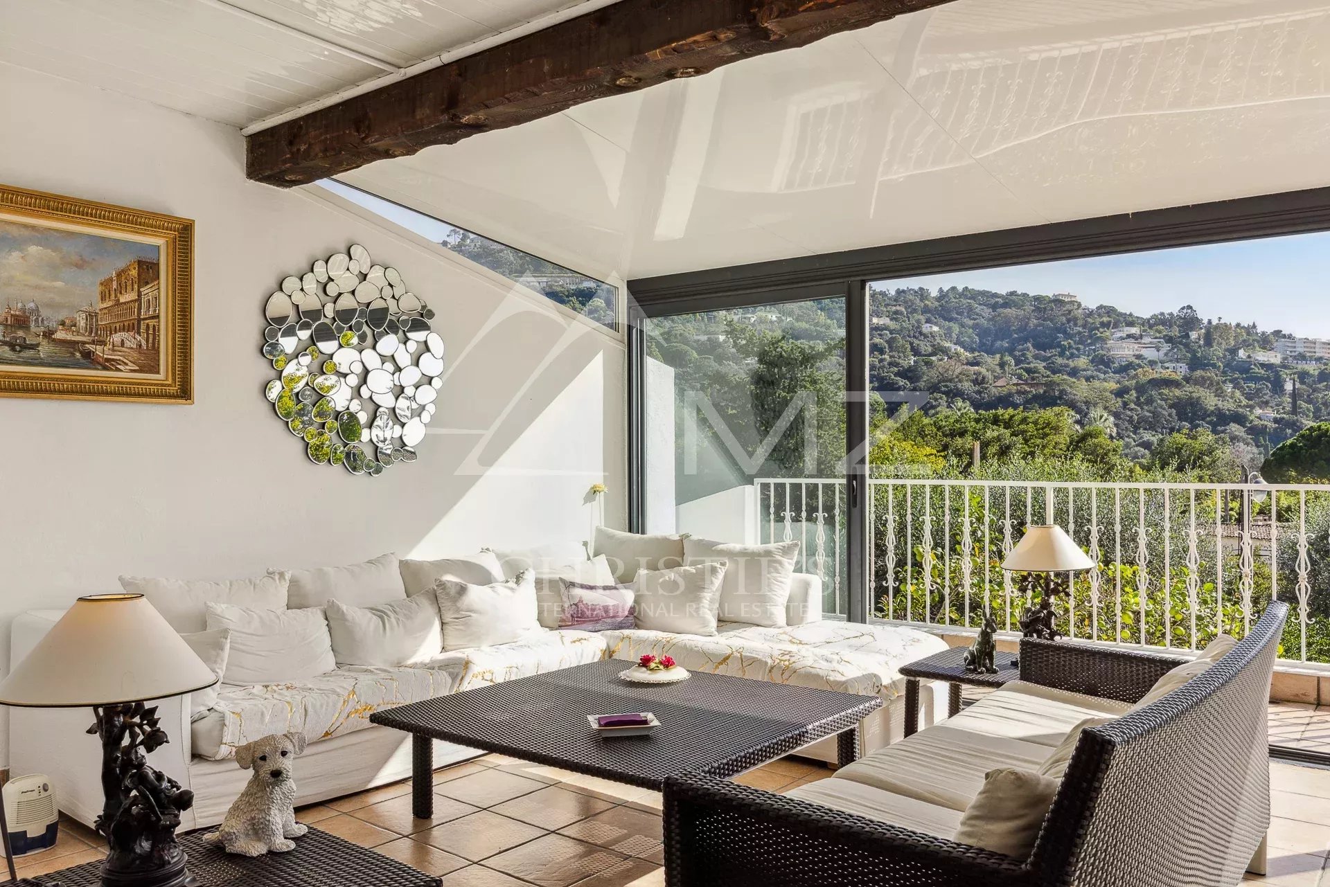 Intérieur d'une villa familiale à Cannes avec salon lumineux et véranda.