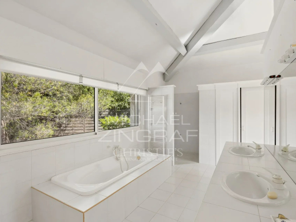 Bright bathroom with bathtub and windows, villa in Antibes.
