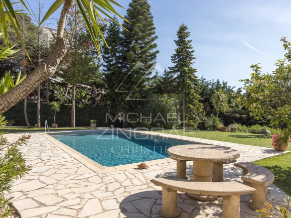 View of a villa with swimming pool and garden in a gated community in Antibes.