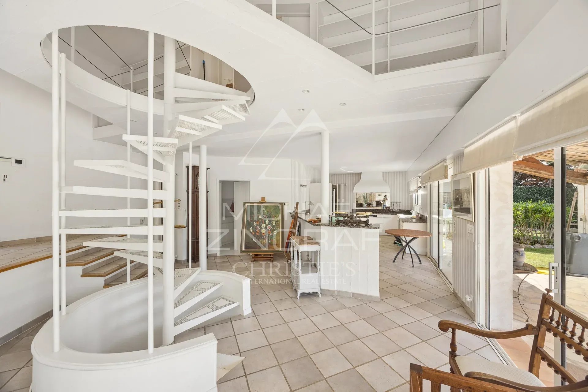 Interior of a villa in Antibes Interior of a villa in Antibes with a spiral staircase and a bright living room.