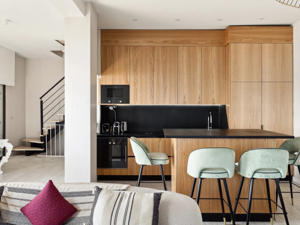 Modern wooden kitchen with bar and high stools in a renovated house in Cannes