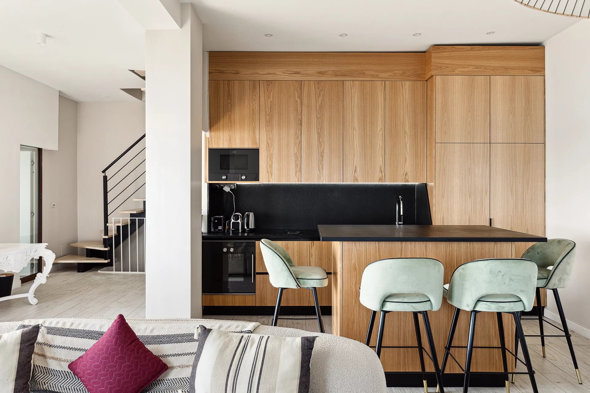 Modern cuisine in Cannes Modern wooden kitchen with bar and high stools in a renovated house in Cannes
