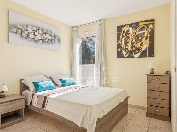 Chambre d'une villa triplex à Cannes, avec lit double et décor sobre.