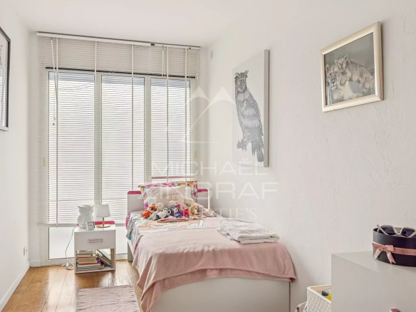 Chambre d'une villa triplex à Cannes, avec lit simple et lumière naturelle.