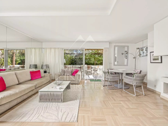 Intérieur d'une villa triplex à Cannes, salon lumineux avec canapé et table à manger.