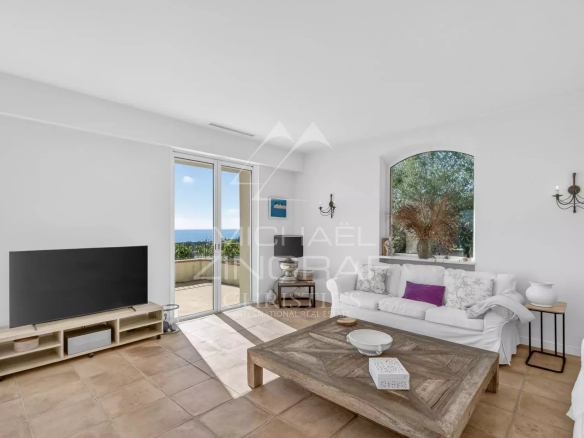 Interior of a stone villa with a bright living room and sea view in Vallauris.