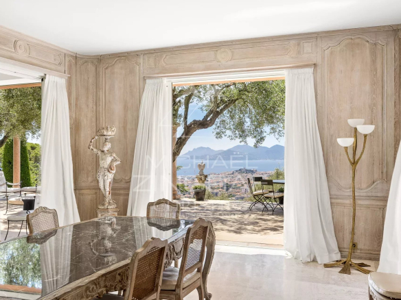 Intérieur d'une maison de maître à Cannes avec vue sur la baie, décor élégant et mobilier raffiné.