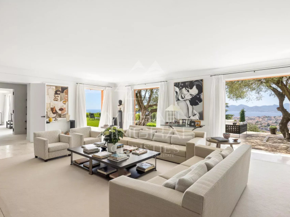Intérieur d'une maison de maître à Cannes, avec salon lumineux et vue sur la baie.