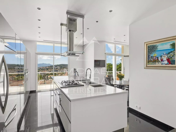 Cuisine moderne et lumineuse avec vue panoramique sur Cannes et les montagnes.