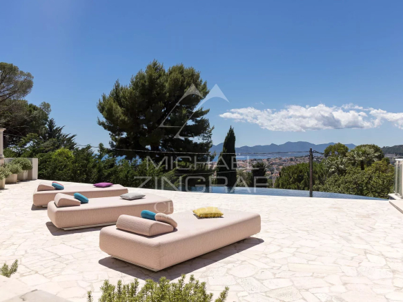 Terrasse avec transats et vue panoramique sur la baie de Cannes et les îles de Lérins.