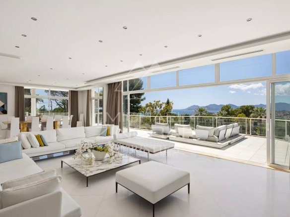 Intérieur d'une propriété contemporaine à Cannes avec vue sur la baie, salon lumineux et moderne.