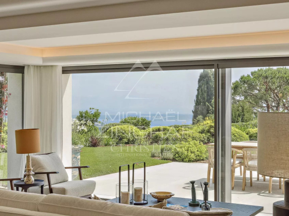 Intérieur d'une villa moderne avec vue sur un jardin paysager et la mer à Cannes.