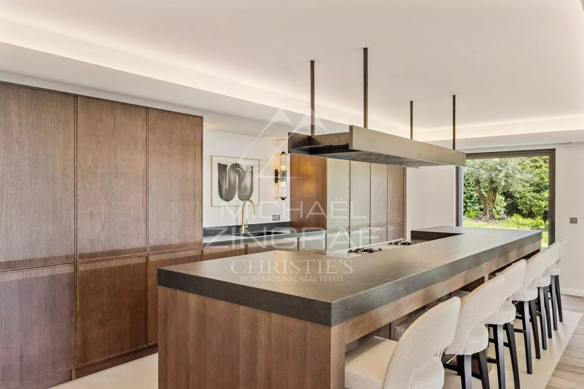 Cuisine d’une villa à Cannes Cuisine moderne et élégante d'une villa à Cannes, avec un grand îlot central et des meubles en bois.