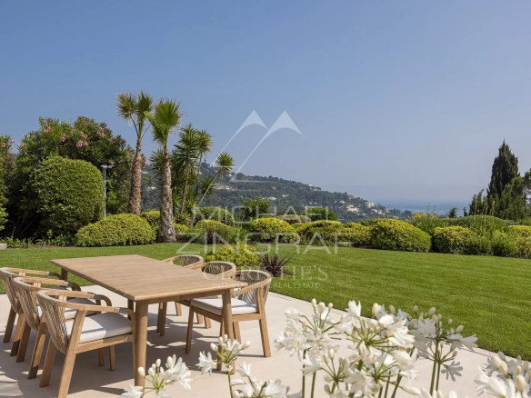 Terrasse ensoleillée avec mobilier en bois et vue sur la mer à Cannes-Californie.
