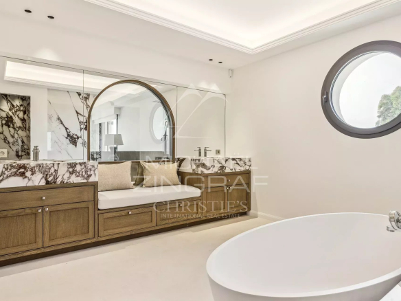 Salle de bain moderne avec baignoire et miroir au design élégant.