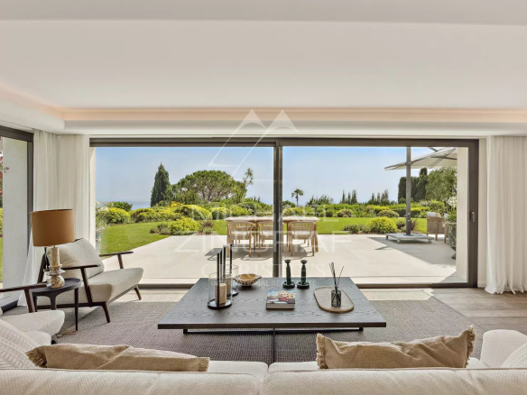 Intérieur d'une villa moderne avec vue sur un jardin paysager à Cannes.