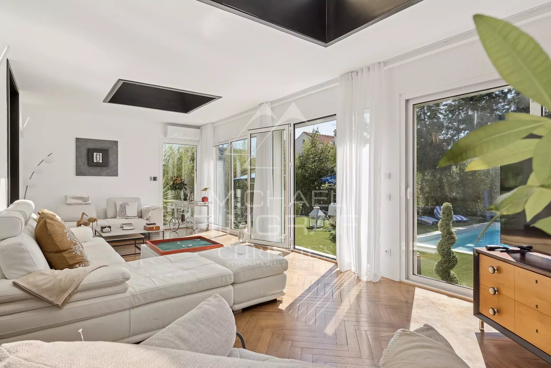 Intérieur d’une villa Art Déco au Cannet Intérieur d'une villa Art Déco rénovée avec un salon lumineux et des fenêtres donnant sur le jardin.