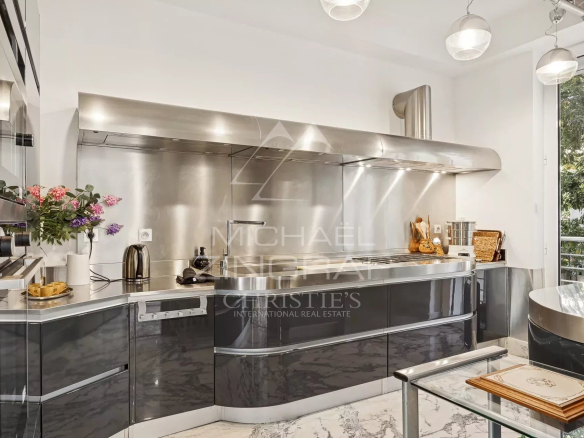 Cuisine moderne avec éléments en acier inoxydable et plan de travail en marbre dans une villa Art Déco au Cannet.