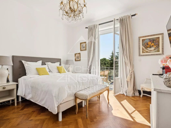 Chambre d'une villa Art Déco à Le Cannet, avec lit double, décoration élégante et lumière naturelle.