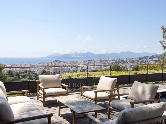 Terrace of a contemporary villa in Cannes with panoramic views of the sea and mountains.