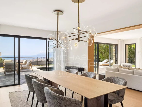 Interior of a contemporary villa in Cannes with sea views, bright dining room and living room.
