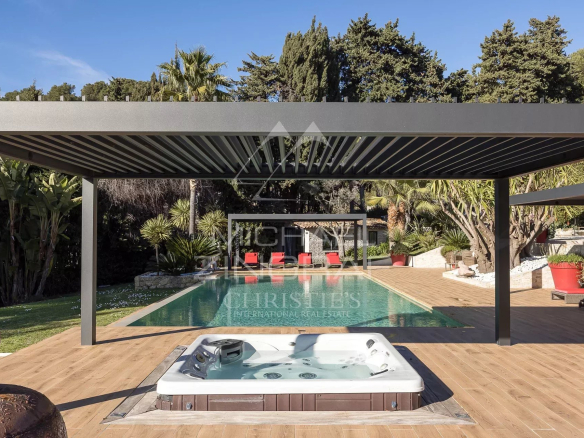 View of a modern swimming pool with jacuzzi and relaxation area in a property in Cannes.