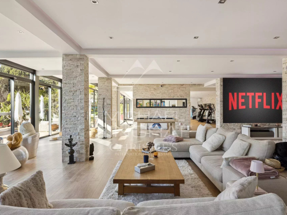 Interior of a modern villa in Cannes with a bright living room and Netflix screen.