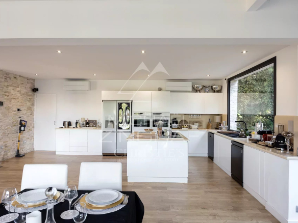 Interior of a modern and bright kitchen with dining table, overlooking the sea in Cannes.