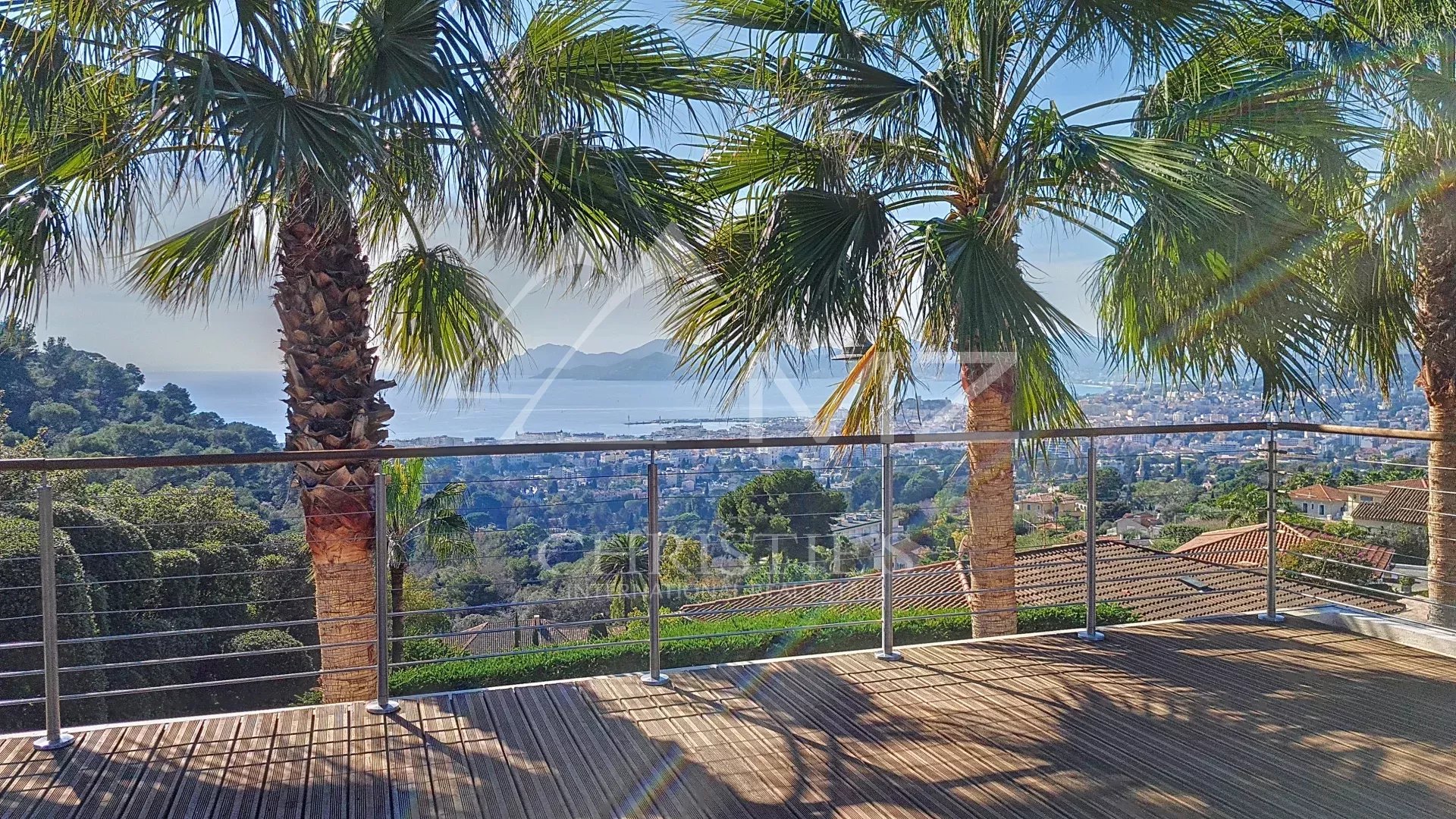 Contemporary villa in Cannes Terrace of a villa in Cannes with views of the sea and palm trees.