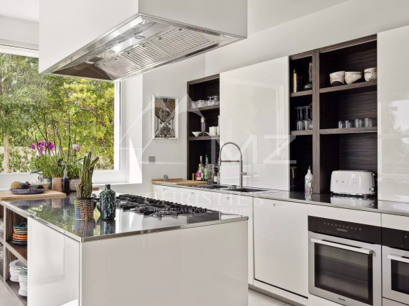 Modern and bright kitchen in a villa in Le Cannet, with central island and views of nature.