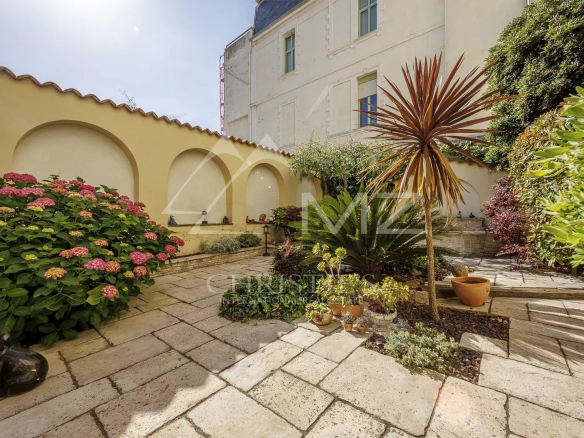 Jardin avec fleurs et plantes devant une maison de pécheurs à Cannes Palm Beach.