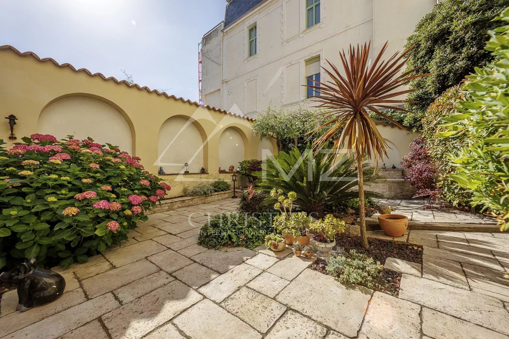Jardin avec fleurs et plantes devant une maison de pécheurs à Cannes Palm Beach.