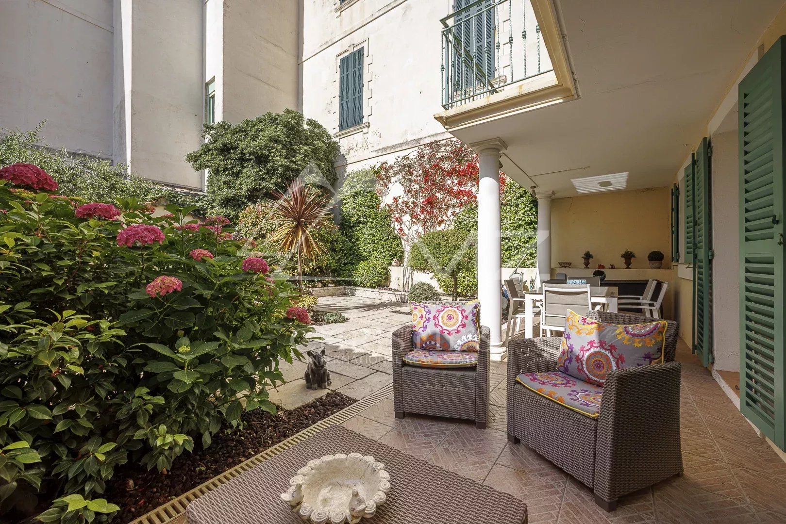 Terrasse d'une maison de pêcheurs à Cannes avec des chaises et des fleurs.
