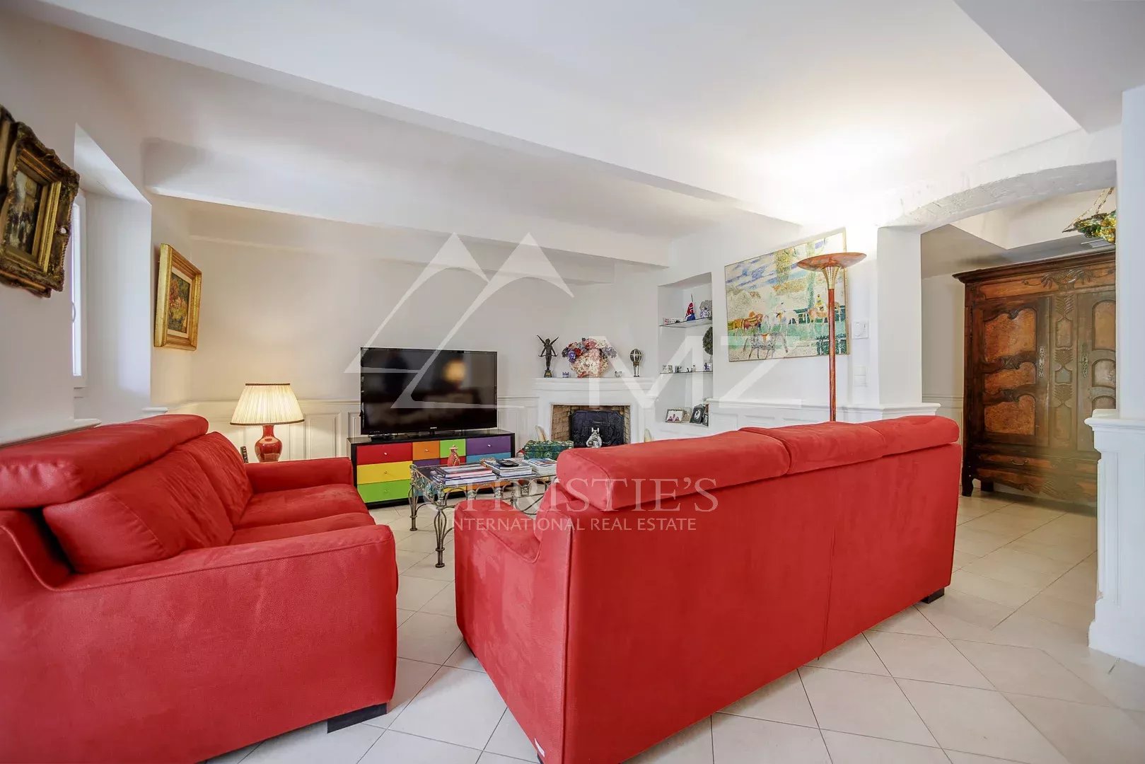 Intérieur d'une maison de pêcheurs à Cannes avec un salon rouge et une décoration moderne.