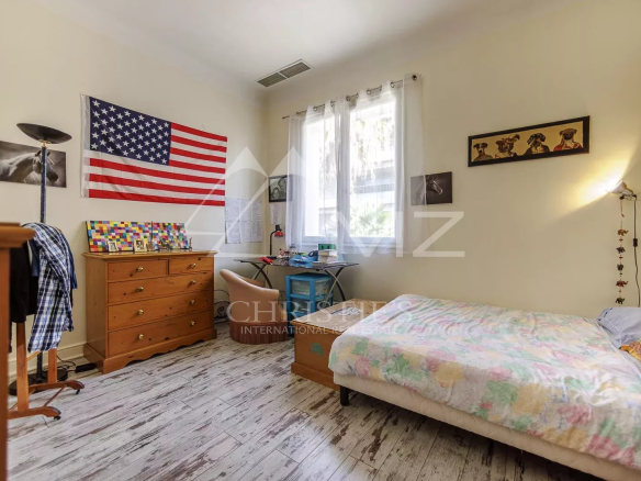 Chambre d'une maison de pêcheurs à Cannes avec un drapeau américain et un lit simple.