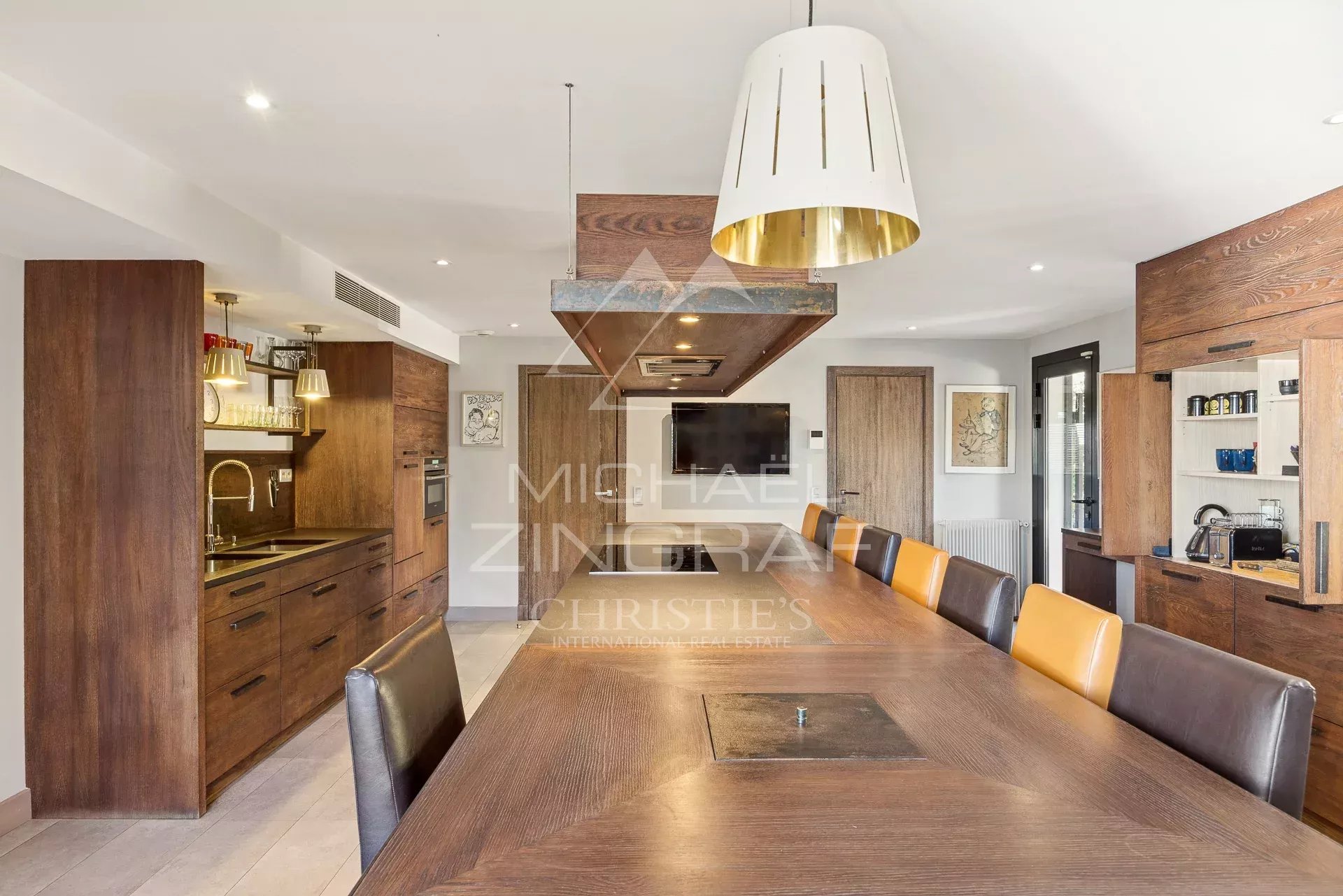 Cuisine moderne au Cannet Cuisine moderne avec un grand plan de travail et des chaises colorées dans une maison au Cannet.