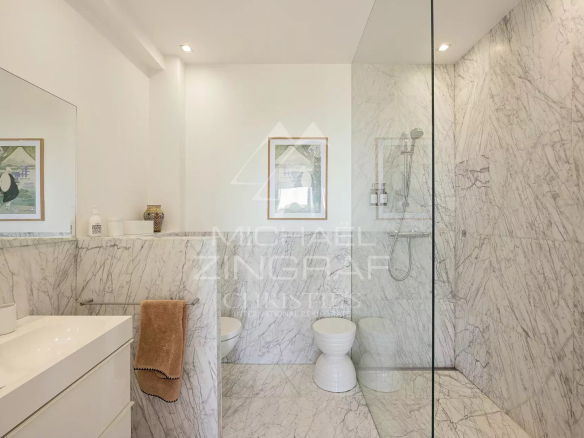 Salle de bain moderne avec murs en marbre et douche à l'italienne.