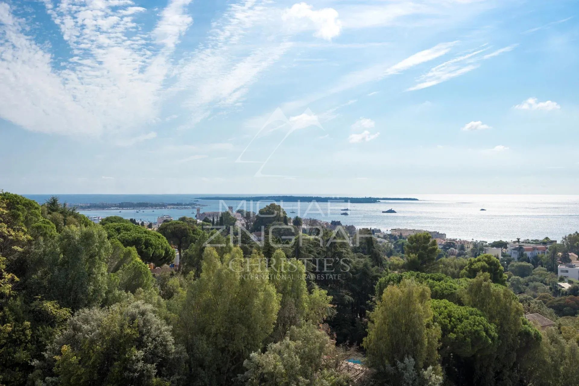 Vue depuis un penthouse à Cannes Vue panoramique sur la Méditerranée depuis un penthouse à Cannes, avec des arbres au premier plan.