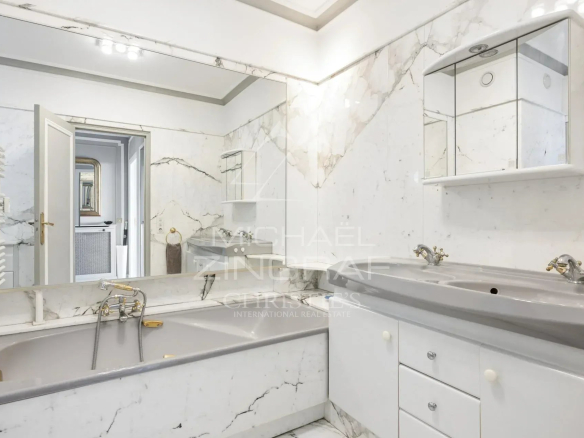 Salle de bain en marbre avec baignoire et lavabo dans un penthouse à Cannes.