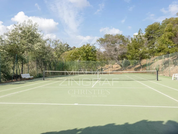 Court de tennis dans une résidence à Cannes, quartier Croix des Gardes, entouré d'arbres.